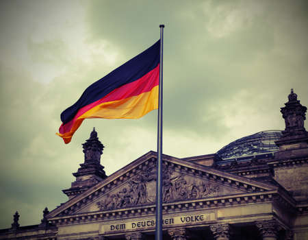 Reichstag building is Parliament of Germany in Berlin city with big flag. The dedication text  over the main entrance DEM DEUTSCHEN VOLKE meaning To the German People. Vintage Effectのeditorial素材