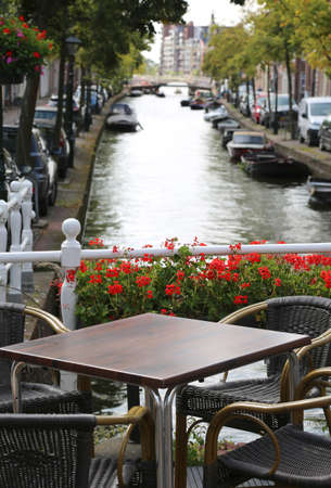 alfresco table of a bar near a wagterway canal with boatsの写真素材