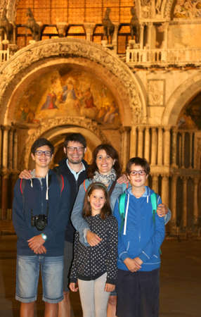 cheerful family of tourists with 3 children and mom and dad visiting venice at nightのeditorial素材