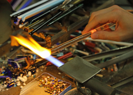 Glassmaker while melting and shaping the glass with a very high temperature flame