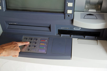 hand of woman press buttons in the keyboard of an ATM machine to give money