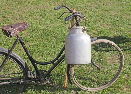 old milking bicycle and aluminum milk canister to deliver milk just moistenedの写真素材
