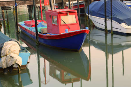 small fishing boat moored in the marina with other boatsの写真素材