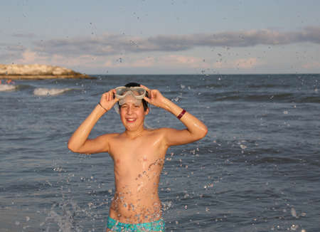 Young kid smiling with diving mask at sea in summerの写真素材