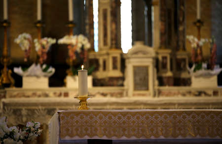 inside a church with the altar and candle lit during Holy Massの写真素材