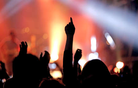 live concert and hand raised of a young fan during the performance of a musical ensemble live concert and hand raised of a young fan during the performance of a musical ensemble