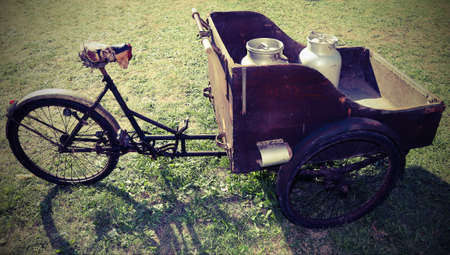 ancient wooden cart with old bicycle to transport the milk just leavened from the farm to the dairy with vintage effectの写真素材