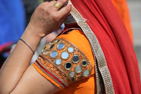 woman dressed with circular mirrors and a red veil during a religious eventの写真素材