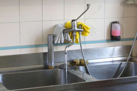 large stainless steel sink in an industrial kitchen for preparing meals in the canteenの写真素材