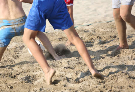 fast athletes during the beach soccer game on the hot sandの写真素材