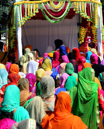 group of people with colorful clothes and women with veil in the head during the religious sikh...
