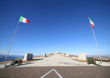 Vicenza, VI, Italy - December 8, 2015: War Memorial of First War World called Ossario del Monte Grappa. Main avenue with two italian flags and old cannonsのeditorial素材