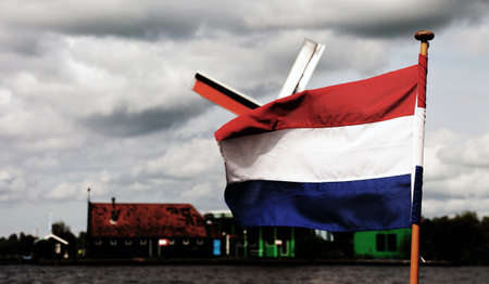 waving the Dutch flags and in the background the windmill the plumbean skyの写真素材
