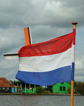 Dutch flag and in the background the windmillの写真素材