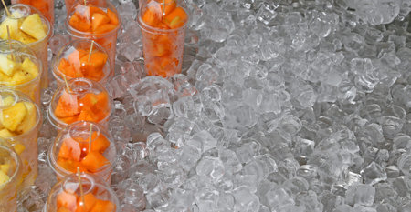 fresh fruit salad with pieces of fruit and ice cubesの写真素材