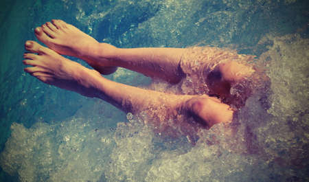 bare feet of a young woman during massage in the pool with vintage effectの写真素材