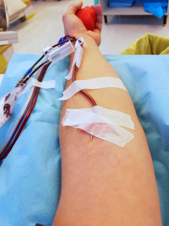 young Blood donor with surgical needle in his armの写真素材