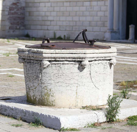 old well to collect rain water on the island of Venice in Italyの写真素材