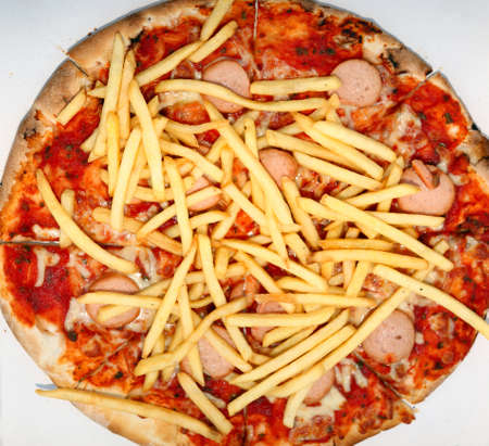 big pizza with fries and wurstel in the pizzeria of takeaway dishesの写真素材
