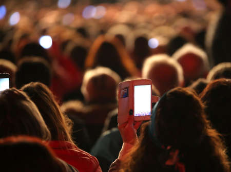 girl film the live concert with the smartphoneの写真素材