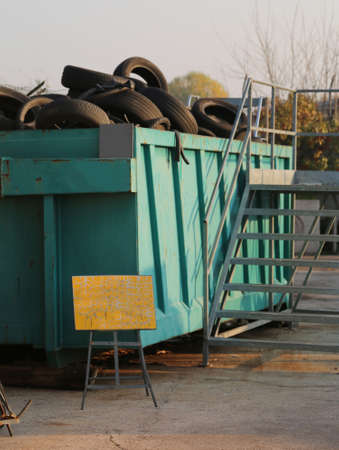 containers with many old tires of cars and trucks in the collection center of recyclable materialの写真素材