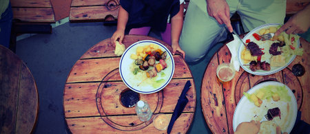 people photographed from above while eating the meal with vintage photo effect