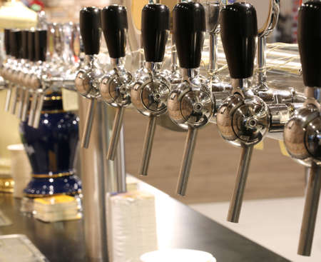 many taps to fill many mugs of beer in the pubの写真素材