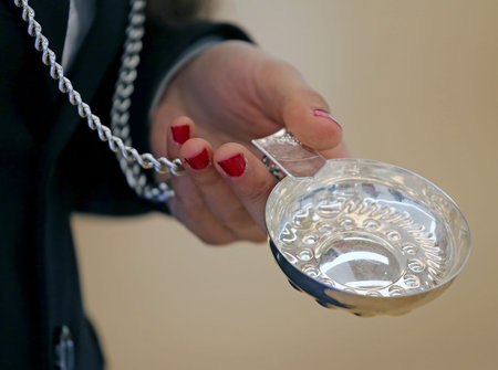 woman with red nail polish in the her hand and the silver saucer to taste the fine wine called...