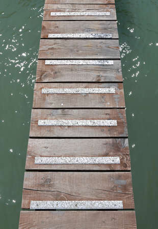 long wooden walkway suspended above the sea without peopleの写真素材