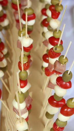 tasty skewers with olive mozzarella and red tomato during the partyの写真素材