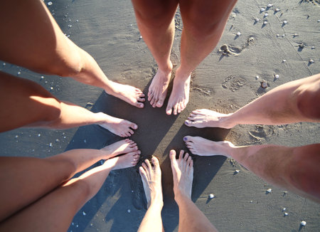 barefoot of the family of five people with father mother and three children on the sea beach in...