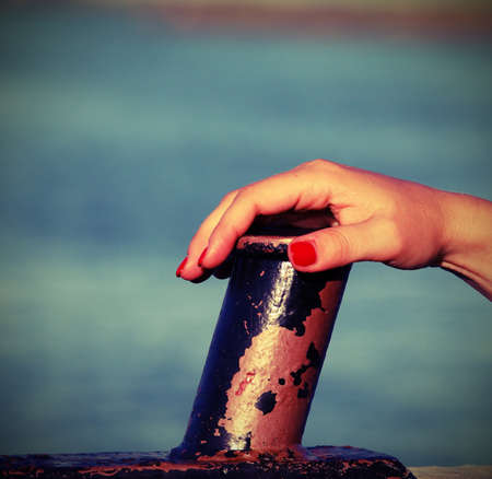 hand of girl with red nails on the yatch with vintage style effectの写真素材