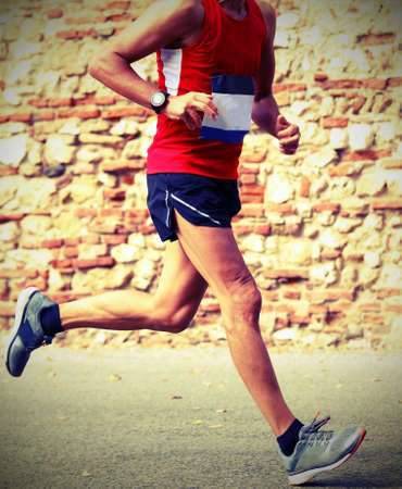 marathon runner runs fast race in town with vintage style effectの写真素材