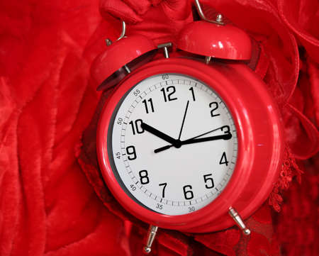 vintage red alarm clock on red backgroundの写真素材