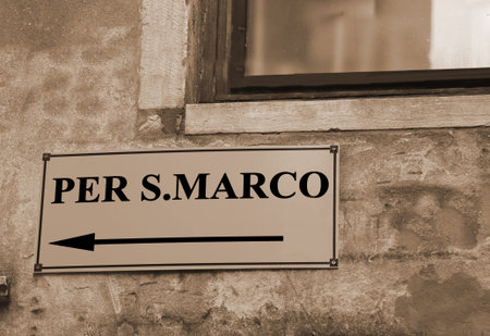signpost with directions to go to St. Mark's Square in Venice in Italy with sepia tonedの写真素材