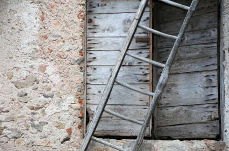 rural Scene with ancient ladder and a wooden old door of a farmの写真素材