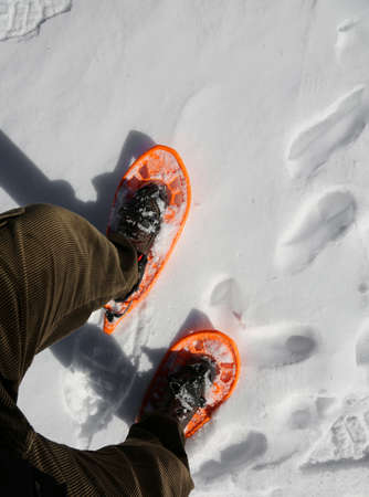 man walks in mountains with snowshoes on the white snowの写真素材
