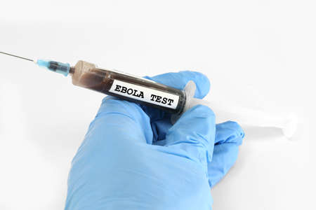 blue glove and a syringe full of blood to be analyzed in the medical laboratory and the text  EBOLA TESTの写真素材