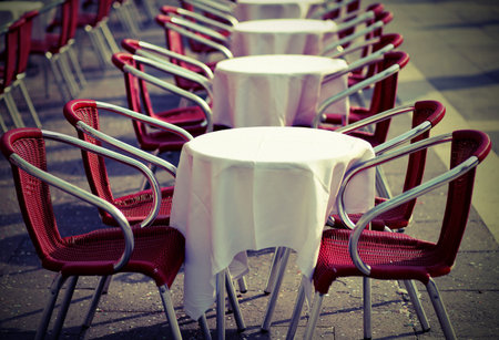 tables and red chairs in an alfresco cafe in the european city with vintage effectの写真素材