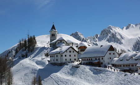 Lussari Mountain, UD, Italy - April 1, 2018: breathtaking view of the ancient Sanctuary and more buildings with snowのeditorial素材