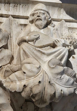 Venice, Italy - July 14, 2016: detail of a statue of a man who plays the special ancient guitar in a column in Saint Mark Square near the Ducal Palaceのeditorial素材