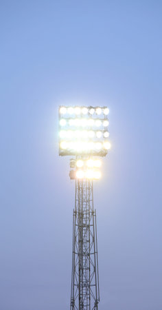 the lighthouse lit during the evening in a soccer field in a dark sky