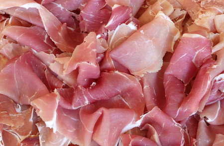 background of slices of raw ham cut to prepare sandwichesの写真素材