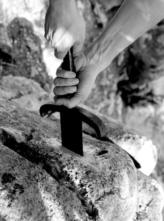 hand of kinight and the Magical Excalibur sword in the stone with black and white effect