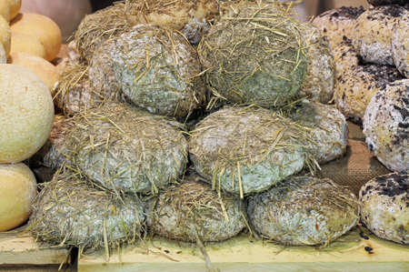 Seasoned cheese covered with straw after aging in a wet caveの写真素材