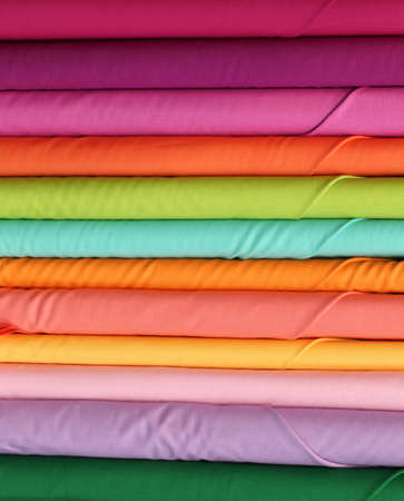 Many rolls of colorful cotton material cloth on the shop's wholesale store specializing in colorful fabricsの写真素材