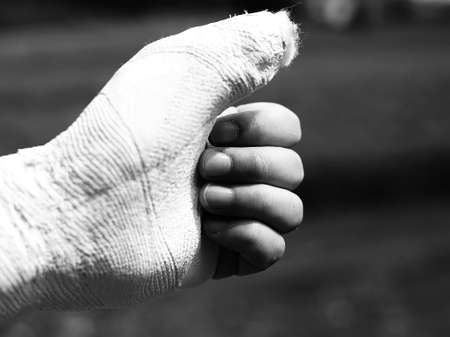 Hand of a person with the thumb pointing upwards and seems to say ok everything is fine with black and white effectの写真素材