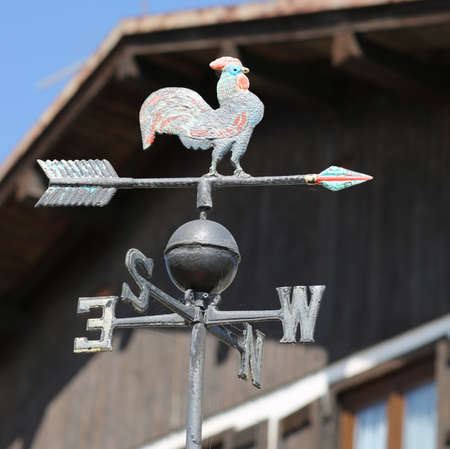 metal vane with a rooster indicating the cardinal points and the wind directionの写真素材