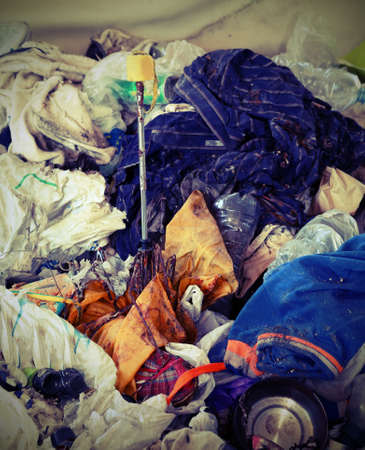 Broken umbrella and many rags abandoned in the shelter of bums full of bacteriaの写真素材