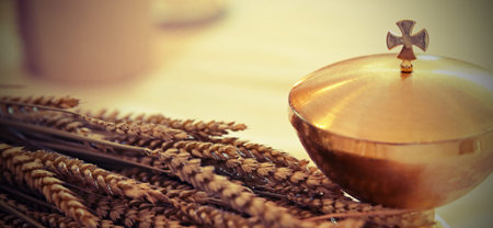 golden chalice and the ears of wheat over an altar in christian church with vintage effect